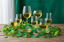 Assorted glasses containing extra virgin olive oil on a wooden table.